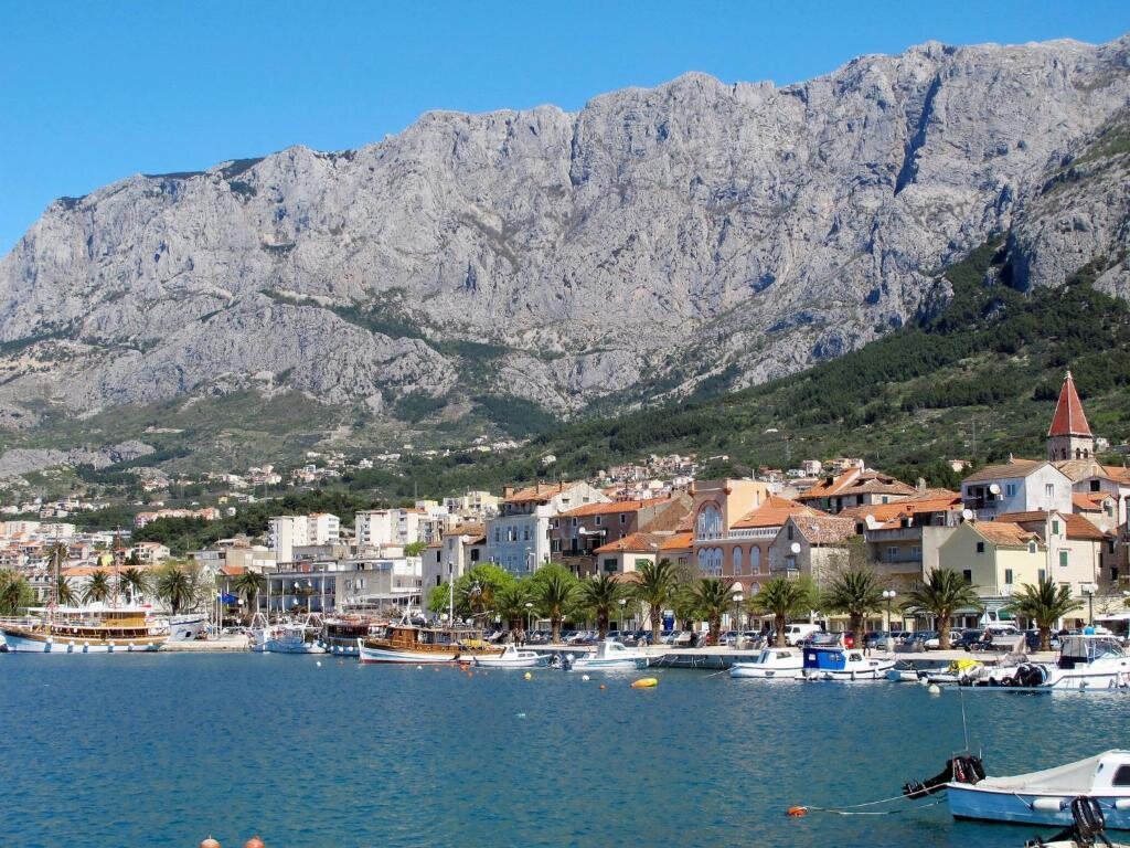 Makarska luka s brodicama i stijene Biokova iznad grada