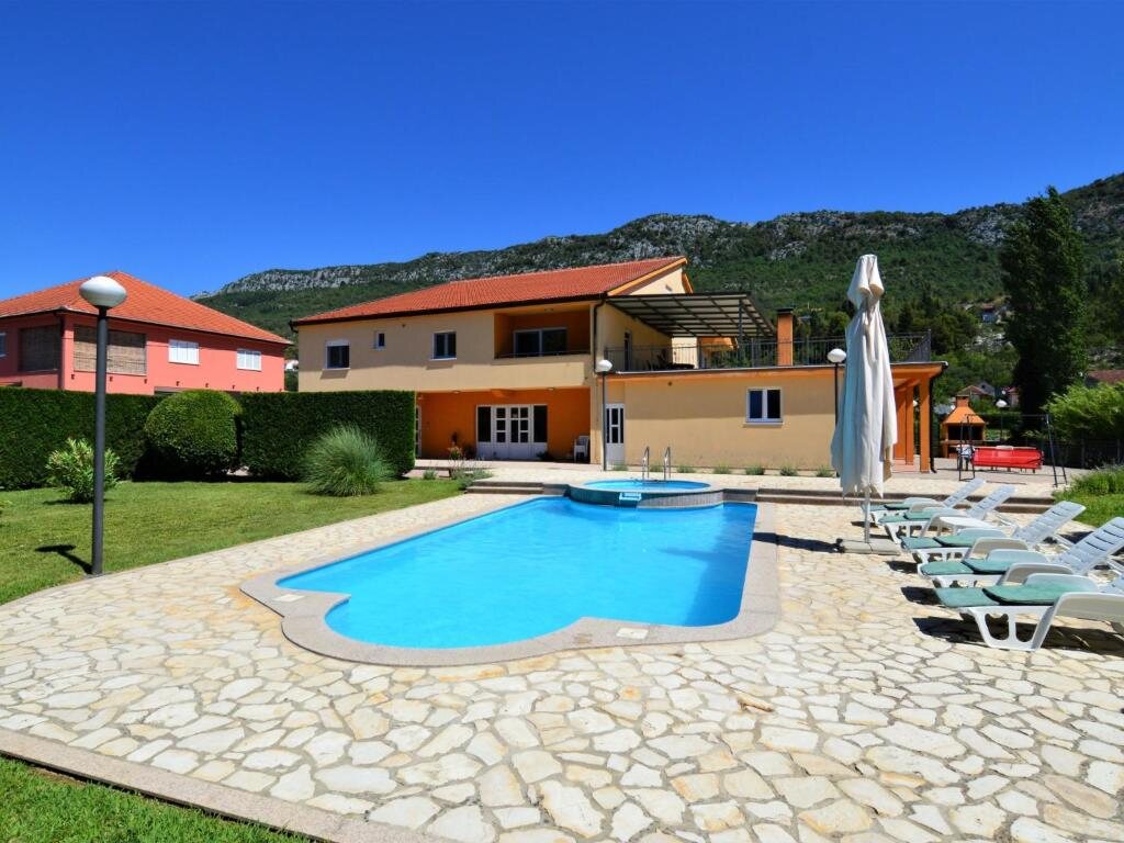 Villa Kikiza u Dušini kraj Vrgorca — bazen ispred kuće i krški brijeg u pozadini