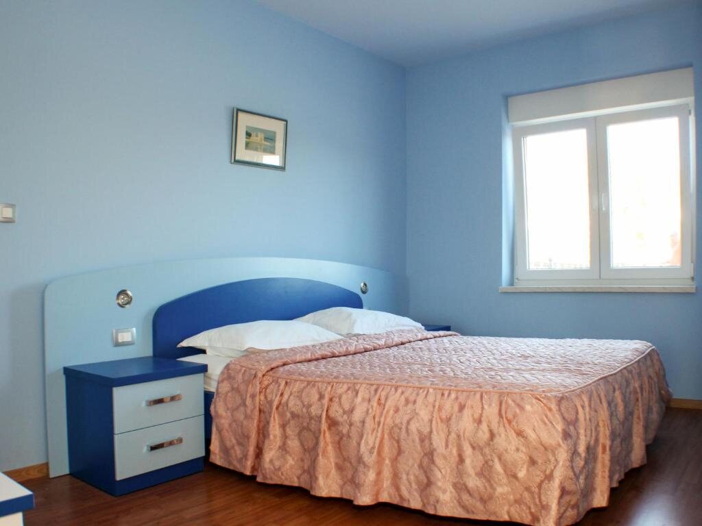 Spavaća soba s plavim zidovima i bračnim krevetom