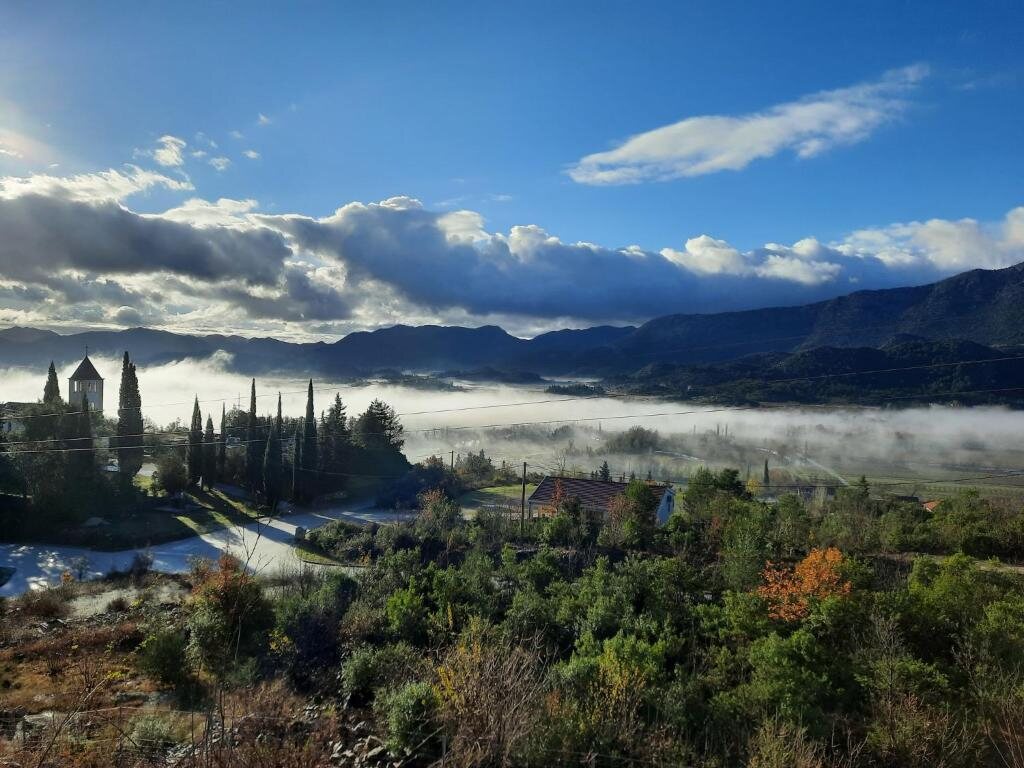 Magla nad Vrgorskim poljem i seoski zvonik u jesenje jutro