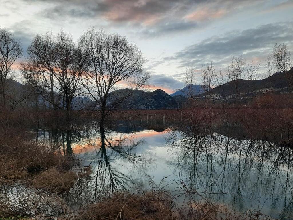 Poplavljeno Vrgorsko polje u sumrak, s odrazom brda u vodi